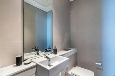 a bathroom with a sink and a mirror and a toilet at EDEN'S Homes & Villas - Atria Residences in Dubai