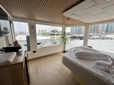 a bedroom with a bed and a view of a boat at Boat Camping in Dubai