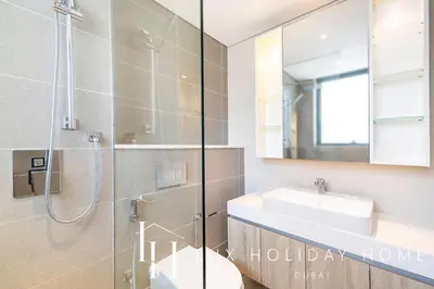 a bathroom with a shower and a sink and a mirror at LUX Contemporary Suite with Marina View 3 in Dubai