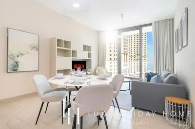 a white dining room with a table and chairs at LUX Contemporary Suite with Marina View 3 in Dubai
