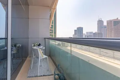 a balcony with a chair and a view of the city at Frank Porter - Indigo Tower in Dubai