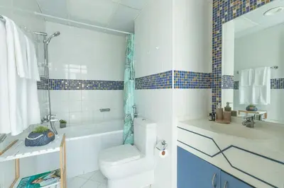 a bathroom with a toilet and a tub and a sink at Frank Porter - Indigo Tower in Dubai