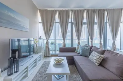 a living room with a couch and a tv at Frank Porter - Indigo Tower in Dubai