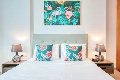 a bedroom with a white bed with two lamps at Manazel Al Safa in Dubai in Dubai