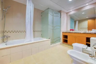 a bathroom with a tub and a shower and a sink at Manazel Al Safa in Dubai in Dubai