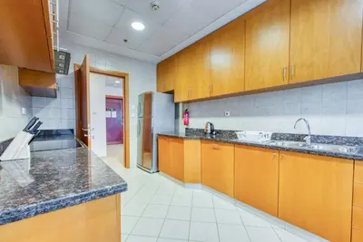 a large kitchen with wooden cabinets and a refrigerator at Manazel Al Safa in Dubai in Dubai