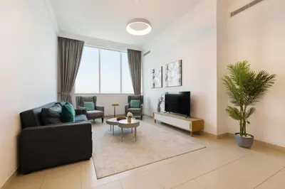 a living room with a couch and a tv at Manazel Al Safa in Dubai in Dubai