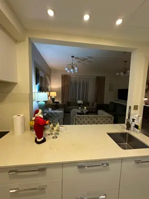 a kitchen counter with a sink and a living room at Magic waves holiday in Dubai