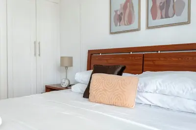 a bedroom with a white bed with a wooden headboard at GuestReady - Marina Views | 1BR + Pool & Gym in Dubai