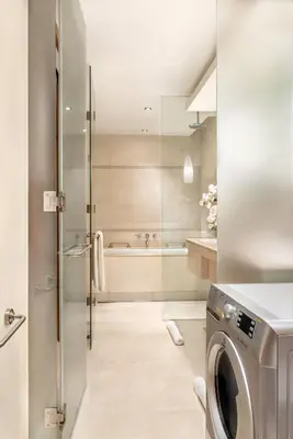 a bathroom with a washing machine and a tub at The H Dubai in Dubai
