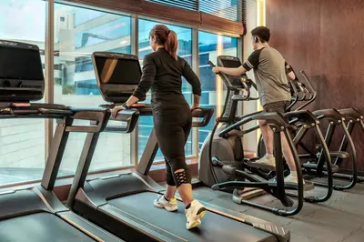 a man and a woman on treadmills in a gym at The H Dubai in Dubai
