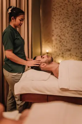 a woman standing next to a man in a bed at The H Dubai in Dubai