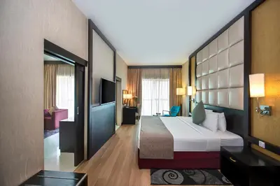 a hotel room with a bed and a television at Grandeur Hotel Al Barsha in Dubai