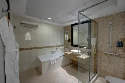 a bathroom with a tub and a sink and a shower at Grandeur Hotel Al Barsha in Dubai