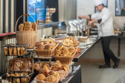 a buffet line with baskets of bread and pastries at Grandeur Hotel Al Barsha in Dubai