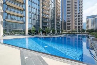 an empty swimming pool in a building with tall buildings at High-End Chic Apartment, Close to Burj Khalifa in Dubai