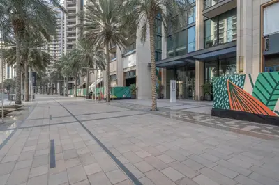 a street with palm trees in front of a building at High-End Chic Apartment, Close to Burj Khalifa in Dubai