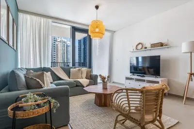a living room with a couch and a tv at High-End Chic Apartment, Close to Burj Khalifa in Dubai