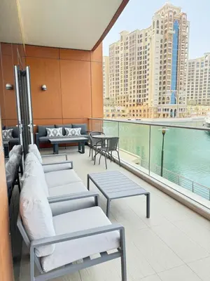 a balcony with benches and tables and a view of the water at Palm Jumeirah 1BR luxurious & gorgeous view in Dubai