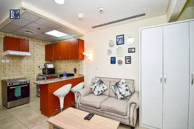 a living room with a couch and a kitchen at Luxury Escapes - Budget Cozy Studio in Dubai Gate 2 JLT in Dubai