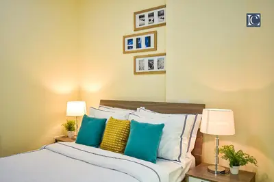 a bedroom with a bed with blue and yellow pillows at Luxury Escapes - Budget Cozy Studio in Dubai Gate 2 JLT in Dubai