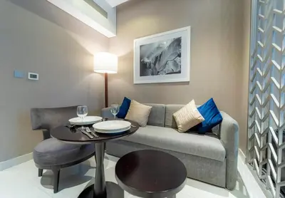 a living room with a couch and a table at AWS Holiday Homes - Panoramic Canal View in Dubai