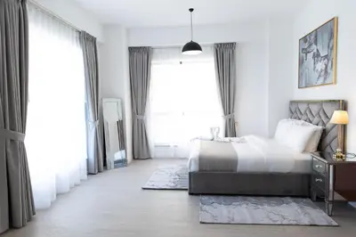 a bedroom with a bed and a large window at JBR apartments by HAPPY SEASON in Dubai