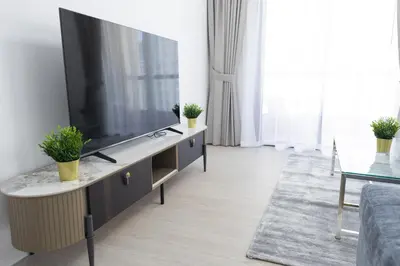 a living room with a flat screen tv on a cabinet at JBR apartments by HAPPY SEASON in Dubai