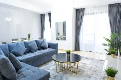 a living room with a blue couch and a table at JBR apartments by HAPPY SEASON in Dubai