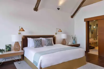 a bedroom with a large bed and two night stands at Anantara World Islands Dubai Resort in Dubai