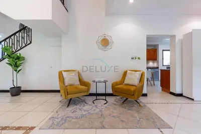two chairs and a table in a living room at Luxury Beachfront Villa with Direct Beach Access, Next to Community Pool, Close to the Thrills of Aquaventure Waterpark, Canal Cove, Palm Jumeirah by Deluxe Holiday Homes in Dubai