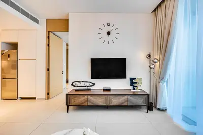 a living room with a tv on a white wall at Brand New 5* Luxury Apartment in Address JBR in Dubai