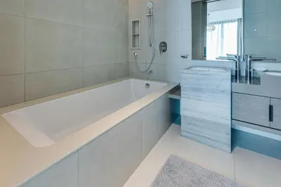 a white bathroom with a tub and a sink at Brand New 5* Luxury Apartment in Address JBR in Dubai