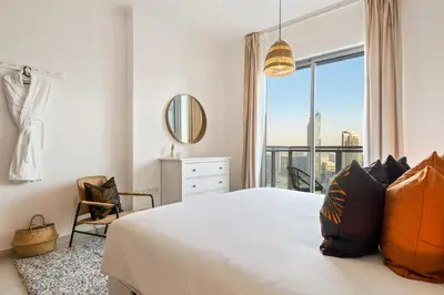 a bedroom with a bed and a large window at Chic and Zen Apartment, Near Burj Khalifa Tower in Dubai