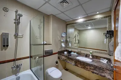 a bathroom with a sink and a shower and a toilet at Orchid Hotel Al Barsha 