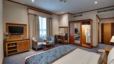 a hotel room with a bed and a television at Orchid Hotel Al Barsha 