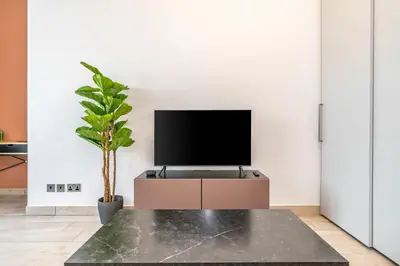 a living room with a tv sitting on a table at Silkhaus studio in DIFC with Burj Khalifa view, pool & gym in Dubai