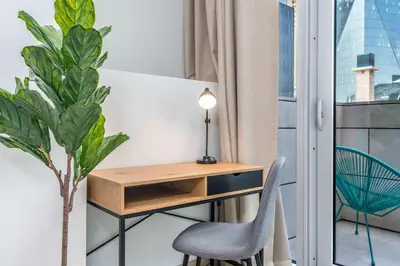 a desk and chair in a room with a window at Silkhaus newly furnished studio facing DIFC with pool and gym access in Dubai