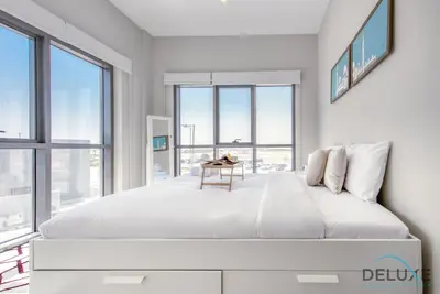 a white bedroom with a large bed and windows at Peaceful 1BR at MAG 505 Dubai South by Deluxe Holiday Homes in Dubai
