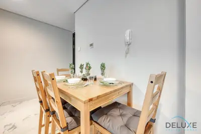 a dining room table with three chairs and a table and chairsuggest at Peaceful 1BR at MAG 505 Dubai South by Deluxe Holiday Homes in Dubai