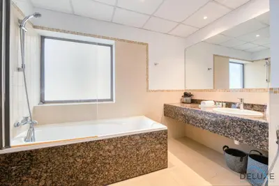 a bathroom with a large tub and two sinks at Elegant 2BR at Bahar 2 JBR by Deluxe Holiday Homes in Dubai