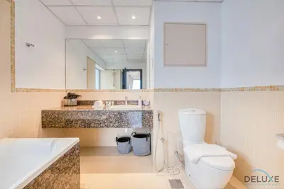a bathroom with a toilet and a sink and a tub at Elegant 2BR at Bahar 2 JBR by Deluxe Holiday Homes in Dubai