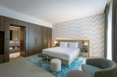 a bedroom with a bed and a couch and a chair at Courtyard by Marriott World Trade Centre, Dubai in Dubai