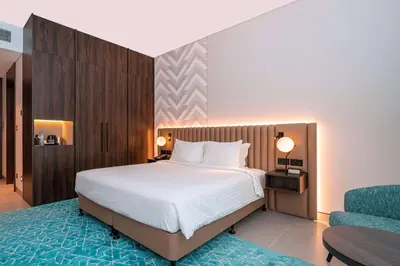 a bedroom with a large bed and a blue rug at Courtyard by Marriott World Trade Centre, Dubai in Dubai