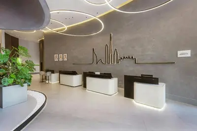 a lobby with white chairs and a wall with a city at Courtyard by Marriott World Trade Centre, Dubai in Dubai