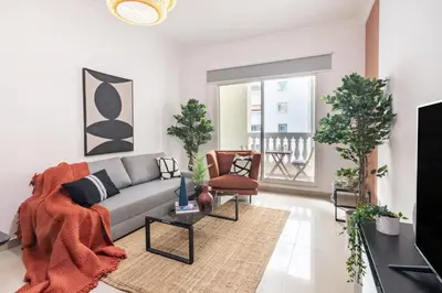 a living room with a couch and a tv at The Smart Concierge - Plaza residences in Dubai