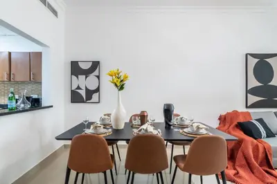 a dining room with a black table and chairs at The Smart Concierge - Plaza residences in Dubai