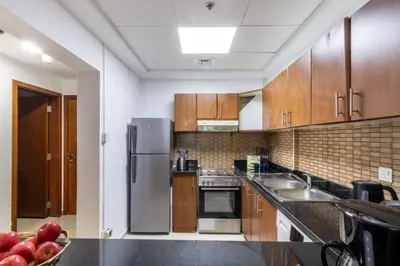 a kitchen with wooden cabinets and stainless steel appliances at The Smart Concierge - Plaza residences in Dubai
