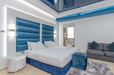 a bedroom with a king sized bed and a couch at Elan Rimal 5 Suites in Dubai