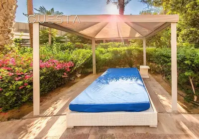 a gazebo with a swimming pool in a garden at Fairmont Apartments The Palm, Free access to hotel beach and pools in Dubai